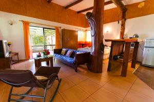 a living room with a blue couch in a room at Cabañas Moai in Hanga Roa