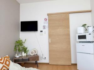 a living room with a door with a microwave at 池袋駅7分 2-5人丨7 minutes from Ikebukuro Station 2-5 people in Tokyo +32 photos