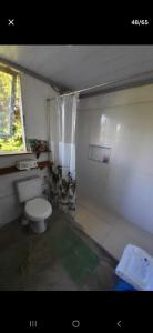 a small bathroom with a toilet and a window at Casa Darwin in Maricá +54 photos