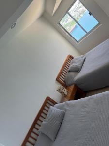 two beds in a room with a window at La Palapa Acapulco in Acapulco +23 photos