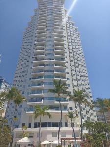 a tall building with palm trees in front of it at La Palapa Acapulco in Acapulco