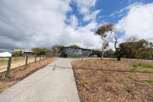 una passerella in un parco con un edificio sullo sfondo di Ocean View Cottage - Anglesea a Anglesea