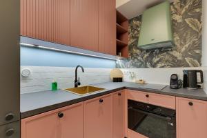 een keuken met oranje kasten en een wastafel bij Żurawie IKONY 2 by Grand Apartments in Gdańsk +11 foto's