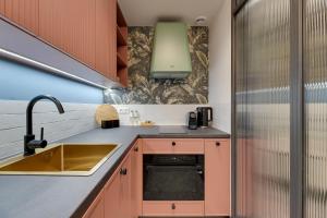 een keuken met een spoelbak en een koelkast bij Żurawie IKONY 2 by Grand Apartments in Gdańsk