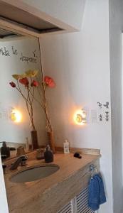 a bathroom with a sink with flowers on the wall at La Palapa Acapulco in Acapulco