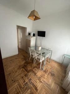 a dining room with a glass table and a refrigerator at Departamento 2 amb centro in Mar del Plata