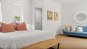 a bedroom with a bed and a blue couch at Byron Centre Apartment with Pool in Byron Bay