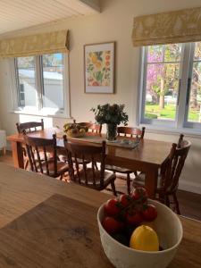 una cucina e una sala da pranzo con tavolo e cesto di frutta di Country Cottage Charm a Mittagong
