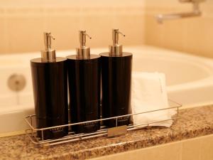 a bathroom with two black bottles on a counter next to a tub at ORDA HOTEL in Chiba +62 photos