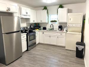 a kitchen with white cabinets and a stainless steel refrigerator at NEW! 2 minutes from Convention Center, Palms Crossing Shopping & South Texas College in McAllen +24 photos
