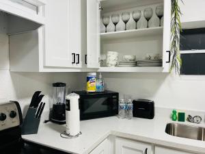 a kitchen with white cabinets and a black microwave at NEW! 2 minutes from Convention Center, Palms Crossing Shopping & South Texas College in McAllen