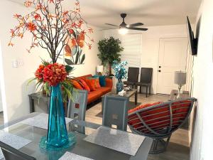 a living room with a vase of flowers on a table at NEW! 2 minutes from Convention Center, Palms Crossing Shopping & South Texas College in McAllen