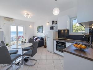 a kitchen and living room with a table and a dining room at Apartments Tafra - One Bedroom Apartment in Lokva Rogoznica