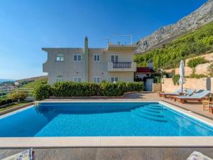 a villa with a swimming pool in front of a house at Apartments Tafra - One Bedroom Apartment in Lokva Rogoznica