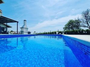 a blue swimming pool with a lighthouse in the background at Villa Cerina - Three Bedorom Villa with Outdoor Swimming Pool in Zagreb