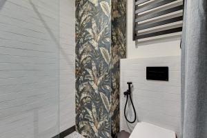 a bathroom with a toilet and a shower curtain at Żurawie by Grand Apartments in Gdańsk