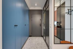 a hallway with blue doors and a mirror at Żurawie by Grand Apartments in Gdańsk +45 photos