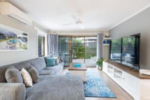 a living room with a couch and a flat screen tv at New Ocean Grove Oasis in Ocean Grove