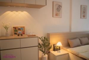 ein Schlafzimmer mit einem Bett und einem Tisch mit einer Lampe in der Unterkunft ChouHouse's Homestay in Hue City 2 in Thôn Văn Dương