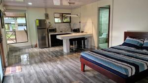 een slaapkamer met een bed en een keuken met een bureau bij House in the Woods in Guápiles