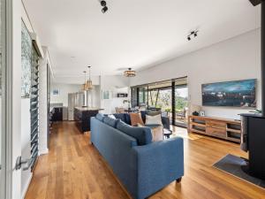 a living room with a blue couch and a tv at Wildflower Ridge in Yallingup