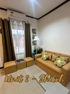 a living room with a brown couch and a window at A and A Homestay Tandag City 