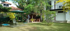 a garden with an umbrella and a table and chairs at Sun Beach Villa in Weligama