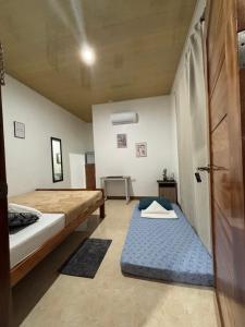 a small room with two beds and a door at Felomina Guesthouse in San Juan