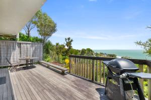 Una motocicleta estacionada en una plataforma de madera con vista al mar. en G SPOT LOWER LEVEL with spa, en Raglan 8 fotos más