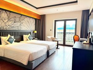 a hotel room with two beds and a balcony at Green Dragon Boutique Hotel in Cẩm Phả +24 photos