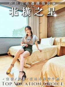 ein Poster einer Frau, die auf einem Bett sitzt in der Unterkunft 北橫之星渡假山莊 in Kao-p'o