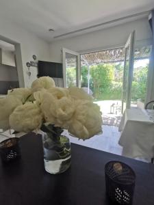 a vase filled with white flowers on a table at Studio jardin privatif 300m de la plage in Sainte-Maxime