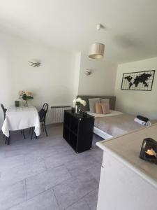 a living room with two beds and a table and a table and a tableablish at Studio jardin privatif 300m de la plage in Sainte-Maxime