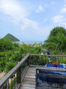 a wooden boardwalk leading to a beach with the ocean at Brassiere Beach Hotel in Baanphakrimlay 