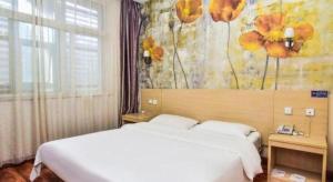 1 Schlafzimmer mit 2 Betten und einem Blumenbild in der Unterkunft Super 8 Hotel Jinan Railway Station Square in Jinan + 133 Fotos