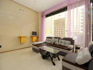 海口市にある7 Days Inn Fucheng Wu Gongci Gaodeng East Street Binjiang Roadのソファとテーブルのあるリビングルーム