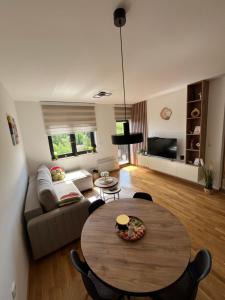 una sala de estar con una mesa y un sofá en Apartman Vidik Spa & Gym Zlatibor, en Zlatibor 24 fotos más