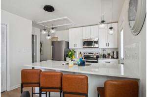 a kitchen with a large white counter and chairs at Your Amazing 3BR2BA Downtown Delight in San Antonio