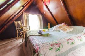 1 dormitorio con cama y ventana en el ático en Cabañas Moai, en Hanga Roa