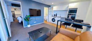 una sala de estar con un sofá y una mesa en Lakevista Haven -- Spa Pool - Hot Tub with Views, en Queenstown