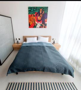 a bedroom with a blue blanket on a bed at Loft студія в Аркадіі з шикарним видом города in Odesa