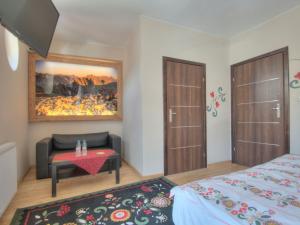 a living room with a bed and a tv at Pokoje Zamoyskiego - WATRA in Zakopane
