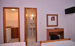 a bathroom with a sink and a toilet and a mirror at Giannis Hotel in Paralia Katerinis