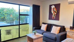 a living room with a couch and a large window at Arcadia Motel in Nelson