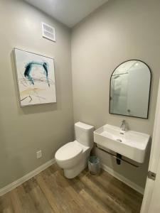 a bathroom with a white toilet and a sink at ENTIRE BACHELOR UNIT EN-SUITE ACROSS FROM GOOGLE - br2 in Kitchener +6 photos