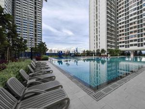 a row of lounge chairs sitting next to a swimming pool at Horizon Staycation w WiFi in Sepang