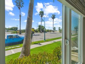 ein Fenster mit Blick auf eine Straße mit Palmen in der Unterkunft Beautiful 2 Bed Beach Condo #104 in Carpinteria + 21 Fotos
