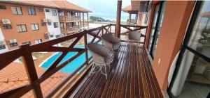 a balcony with chairs and a view of a pool at Apartamento aconchego Atalaia in Luis Correia