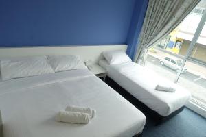 - 2 lits dans une chambre avec fenêtre dans l'établissement Lodge 10 Hotel, à Seremban