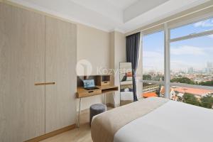 a bedroom with a bed and a desk and a window at Alden by Kozystay - Menteng in Jakarta +26 photos